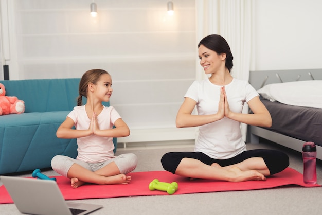 La gente está mirando la computadora portátil en yogmat.