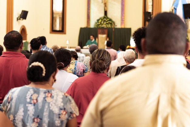 La gente está sentada en la iglesia durante una misa católica.