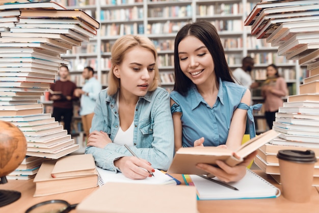 La gente está sentada a la mesa rodeada de libros.