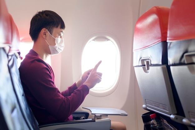 La gente está tocando la pantalla virtual en el concepto de transporte y tecnología moderna del avión