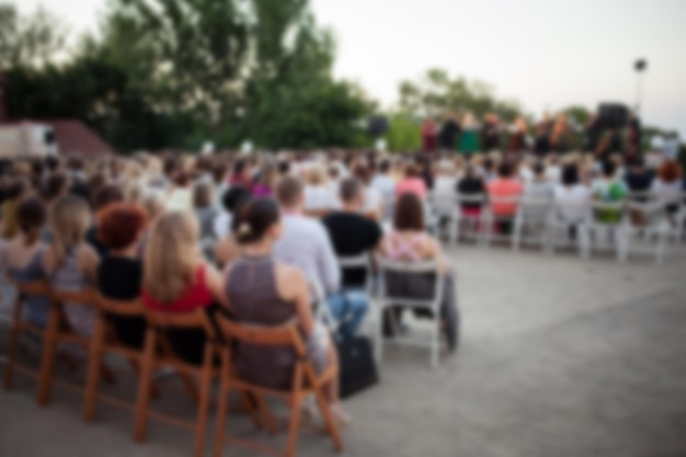 La gente está viendo un concierto de música clásica a la luz del día en un ambiente al aire libre imagen borrosa