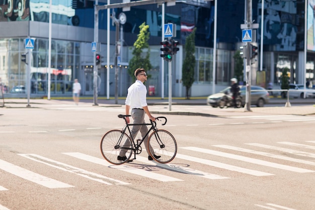 gente, estilo y concepto de estilo de vida - joven con cruce de bicicletas en la calle de la ciudad