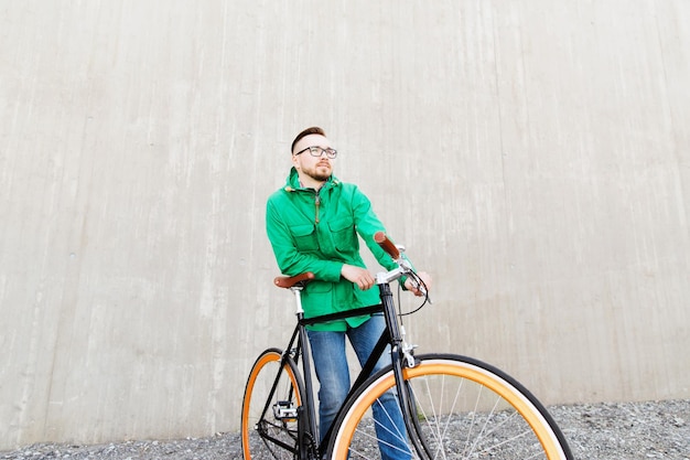 gente, estilo, ocio y estilo de vida - feliz joven hipster con bicicleta fija en la calle de la ciudad