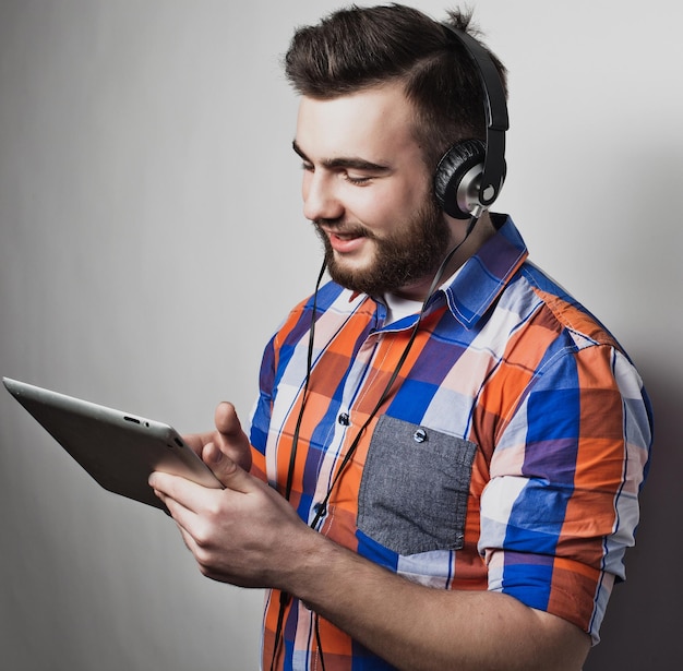 Foto gente de estilo de vida y concepto de educación hombre escuchando audiolibros a través de auriculares sobre fondo blanco