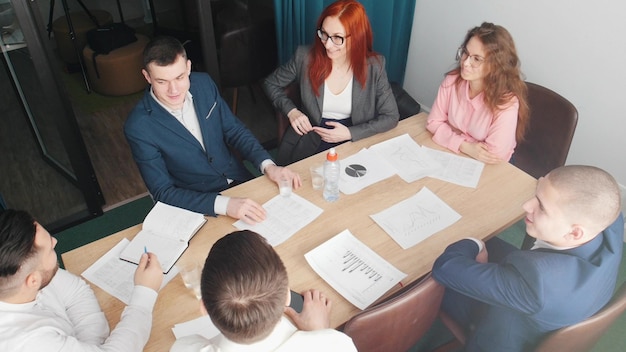 Gente exitosa en la conferencia de negocios hablando junto a la mesa