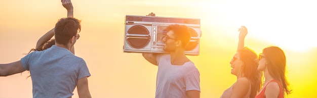 La gente feliz bailando con un boom box en el fondo soleado