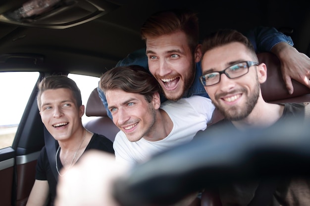 Gente feliz de diferentes grupos étnicos en el coche.