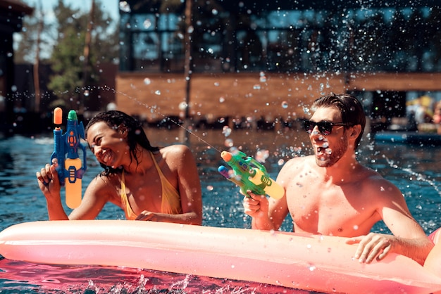 Gente feliz jugando juntos con agua colorida