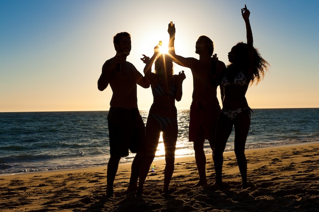 Foto gente de fiesta en la playa con bebidas