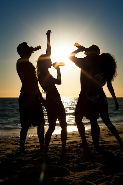 Gente de fiesta en la playa con bebidas