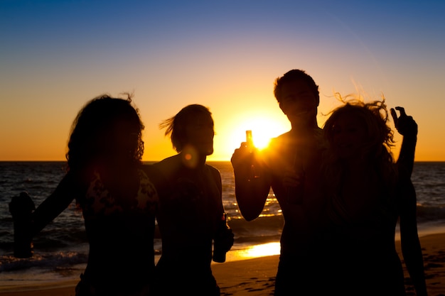 Gente de fiesta en la playa con bebidas