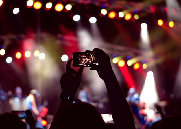 Foto gente fotografiando en un concierto de música.