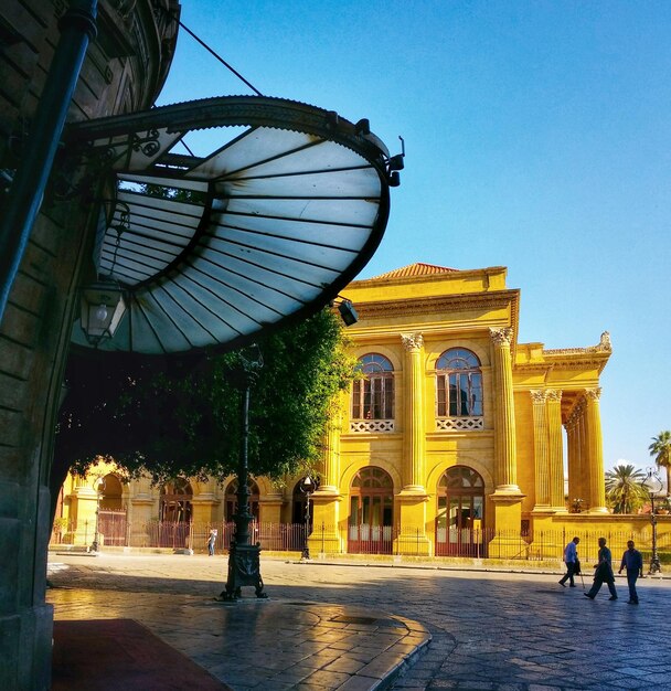 Foto gente frente al edificio neoclásico del teatro