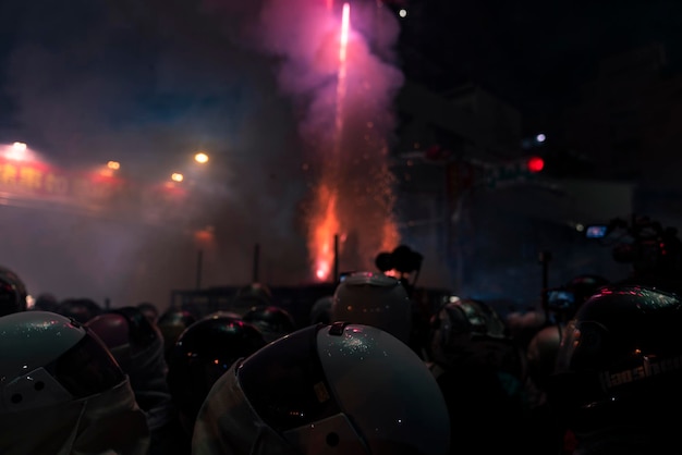 Gente frente a un espectáculo de fuegos artificiales por la noche