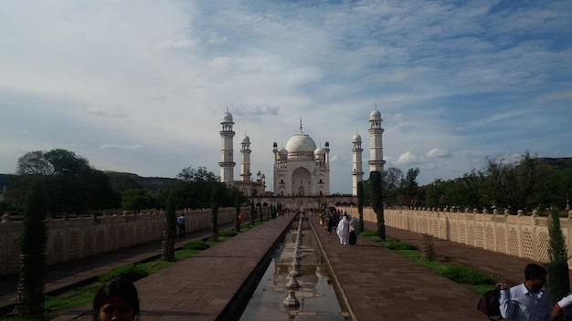 La gente fuera de Bibi ka maqbara contra el cielo