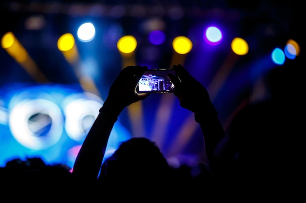 La gente hace fotos con su teléfono inteligente en conciertos