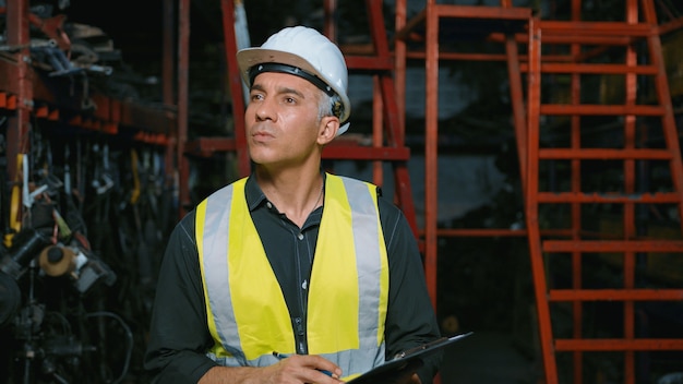 La gente de ingeniería está trabajando en la fábrica de piezas de motor de la planta industrial pesada.