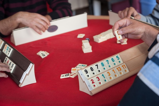 La gente juega al popular juego de mesa de lógica rummikub