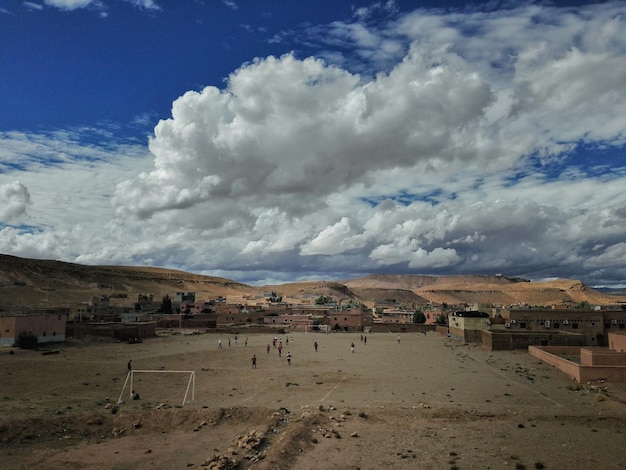 Foto gente jugando al fútbol contra el cielo nublado