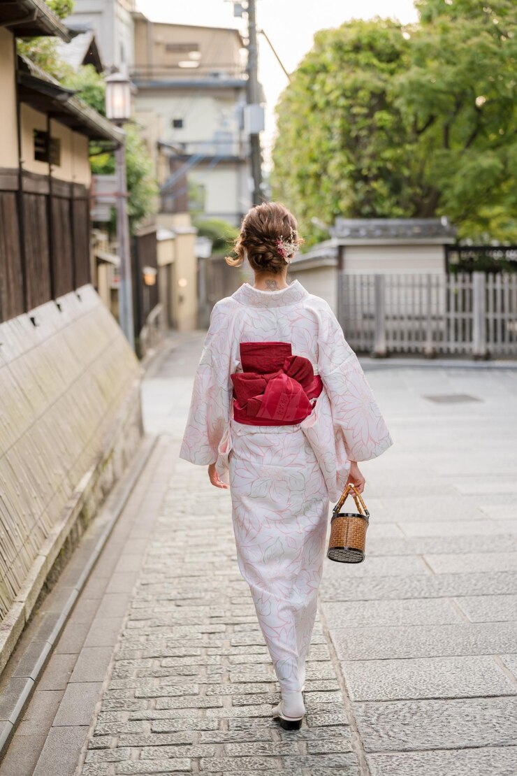 La gente lleva kimono en Kioto, Japón, con un fondo tradicional japonés.