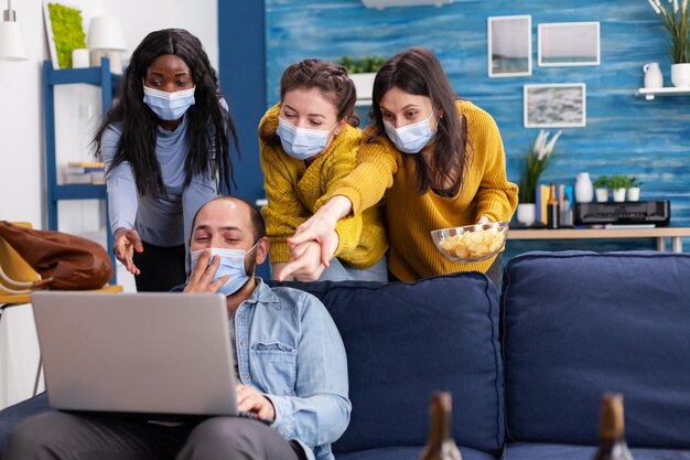 Foto gente con máscara mirando una computadora portátil