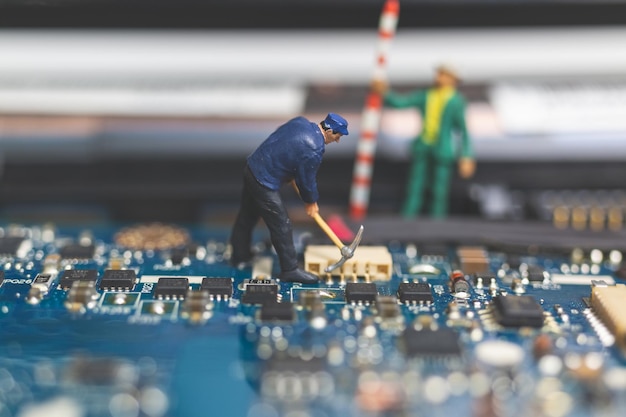 Gente en miniatura Equipo de ingenieros que reparan el teclado de una computadora portátil