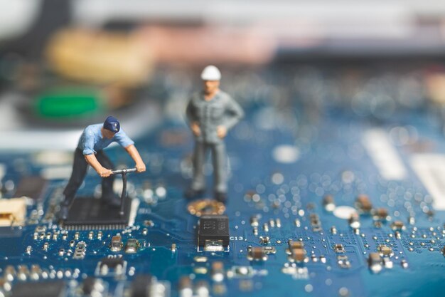 Gente en miniatura Equipo de ingenieros que reparan el teclado de una computadora portátil