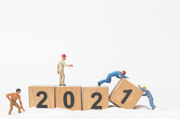 Gente en miniatura: el equipo de trabajadores crea el bloque de madera número 2021, concepto de feliz año nuevo