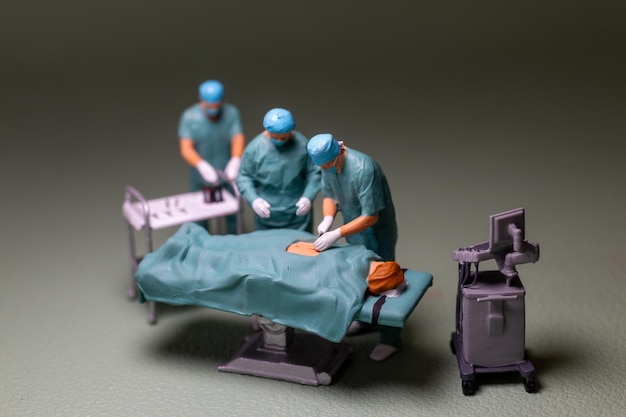 Gente en miniatura escena de cirugía del personal médico en progreso típica de un entorno de sala de operaciones