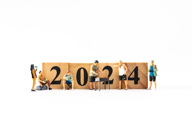 Gente en miniatura Una familia alegre disfruta de las celebraciones de Año Nuevo 039 con un bloque de madera 2024