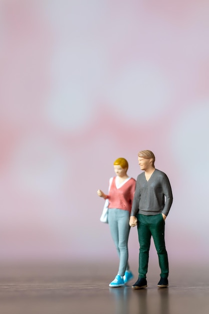 Gente en miniatura hombre y mujer en ropa casual de pie juntos sobre fondo rosa