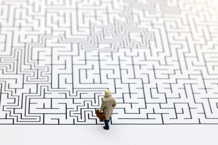 Foto gente miniatura: hombre de negocios de pie en el inicio del laberinto.