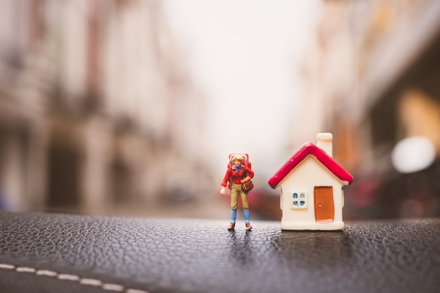 Gente miniatura, mujer que viaja con mini casa usando como concepto de negocios y turismo - Vi