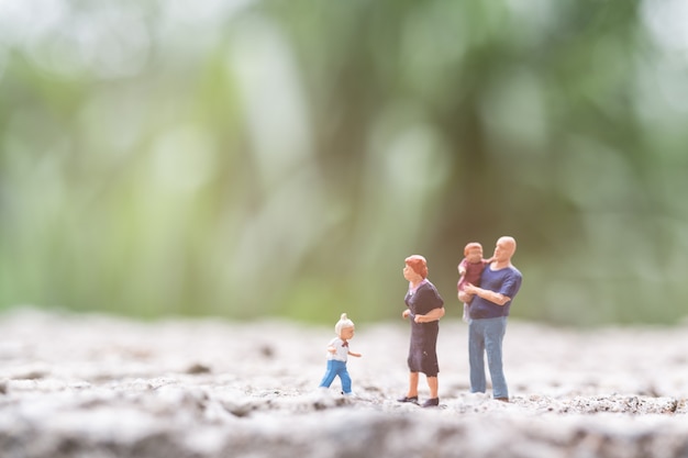 Gente en miniatura: padres con niños caminando al aire libre