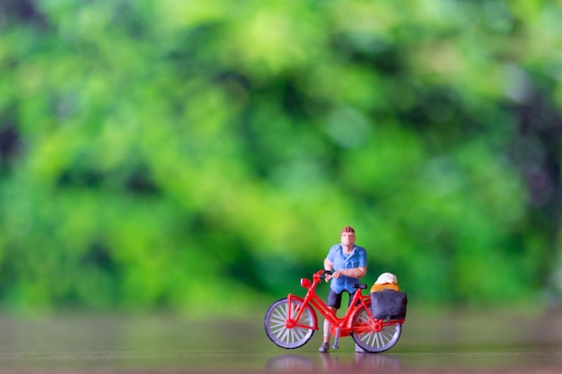 Gente en miniatura de pie con bicicleta Concepto del día mundial de la bicicleta