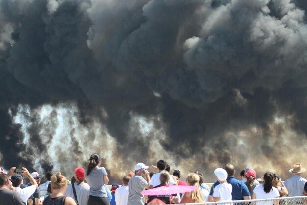 Foto la gente mirando el humo en el espectáculo aéreo