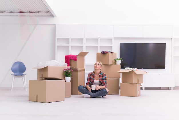 gente, mudarse a un nuevo lugar y reparar el concepto feliz y hermosa mujer joven con muchas cajas de cartón sentadas en el suelo con la Copa en casa