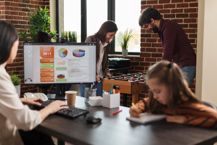 Foto gente de negocios de la agencia jugando fútbol de mesa mientras una mujer joven trabaja sentada en la computadora. compañeros de trabajo en el lugar de trabajo disfrutando del tiempo libre juntos mientras tienen una competencia de fútbol de mesa en el espacio de trabajo.