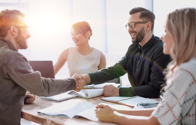 Gente de negocios de apretón de manos en una reunión en la oficina