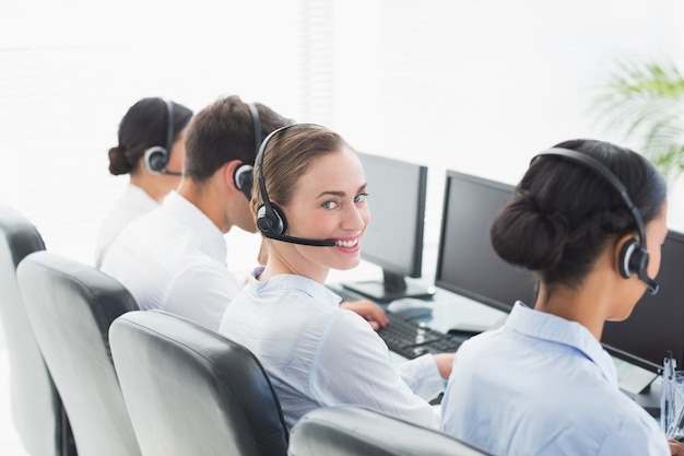 Gente de negocios con auriculares utilizando computadoras.