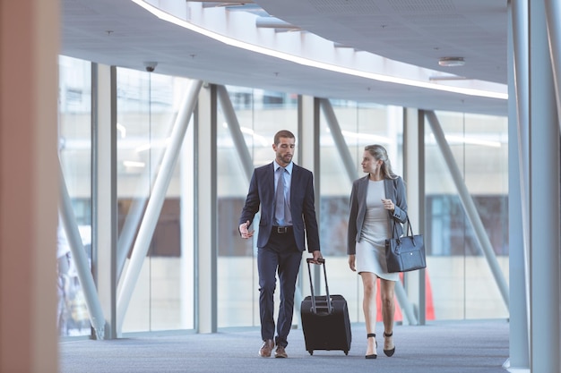 Foto gente de negocios caminando juntos en el corredor de un edificio de oficinas moderno