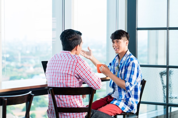 Gente de negocios casual asiática discutiendo en la oficina