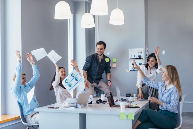 Gente de negocios celebrando y divirtiéndose en la oficina.