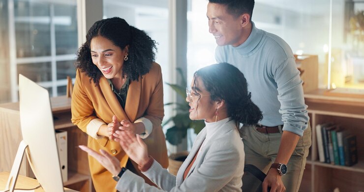 Foto gente de negocios y celebrar por el éxito del trabajo en equipo apoyo y colaboración con la computadora en la oficina celebración hombre y mujer felices juntos con orgullo o felicitaciones por el trabajo retroalimentación