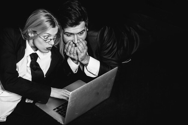 La gente de negocios, colegas de negocios pareja aislada sobre fondo negro con ordenador portátil