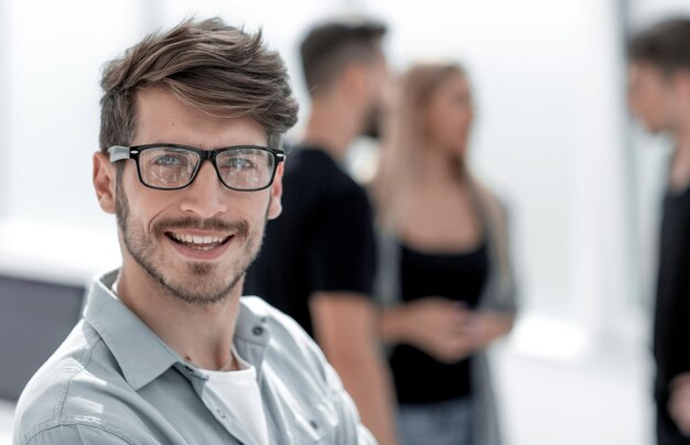 Gente de negocios y concepto de trabajo en equipo mujer de negocios sonriente señalando con el dedo hacia arriba con un grupo de empresarios reunidos en la oficina