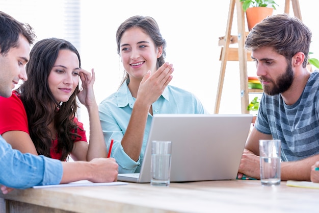 Gente de negocios creativos que usa la computadora portátil en la reunión