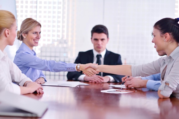 la gente de negocios se da la mano, hace un trato y firma un contrato en una oficina moderna y luminosa