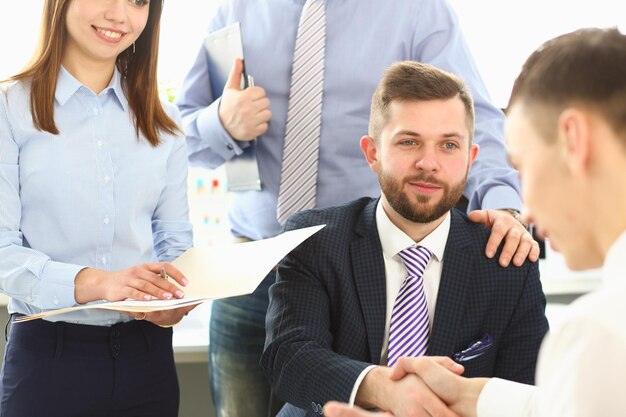 La gente de negocios se da la mano y termina la reunión en primer plano