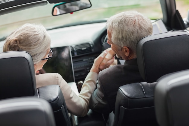 Gente de negocios dándose la mano en convertible con clase